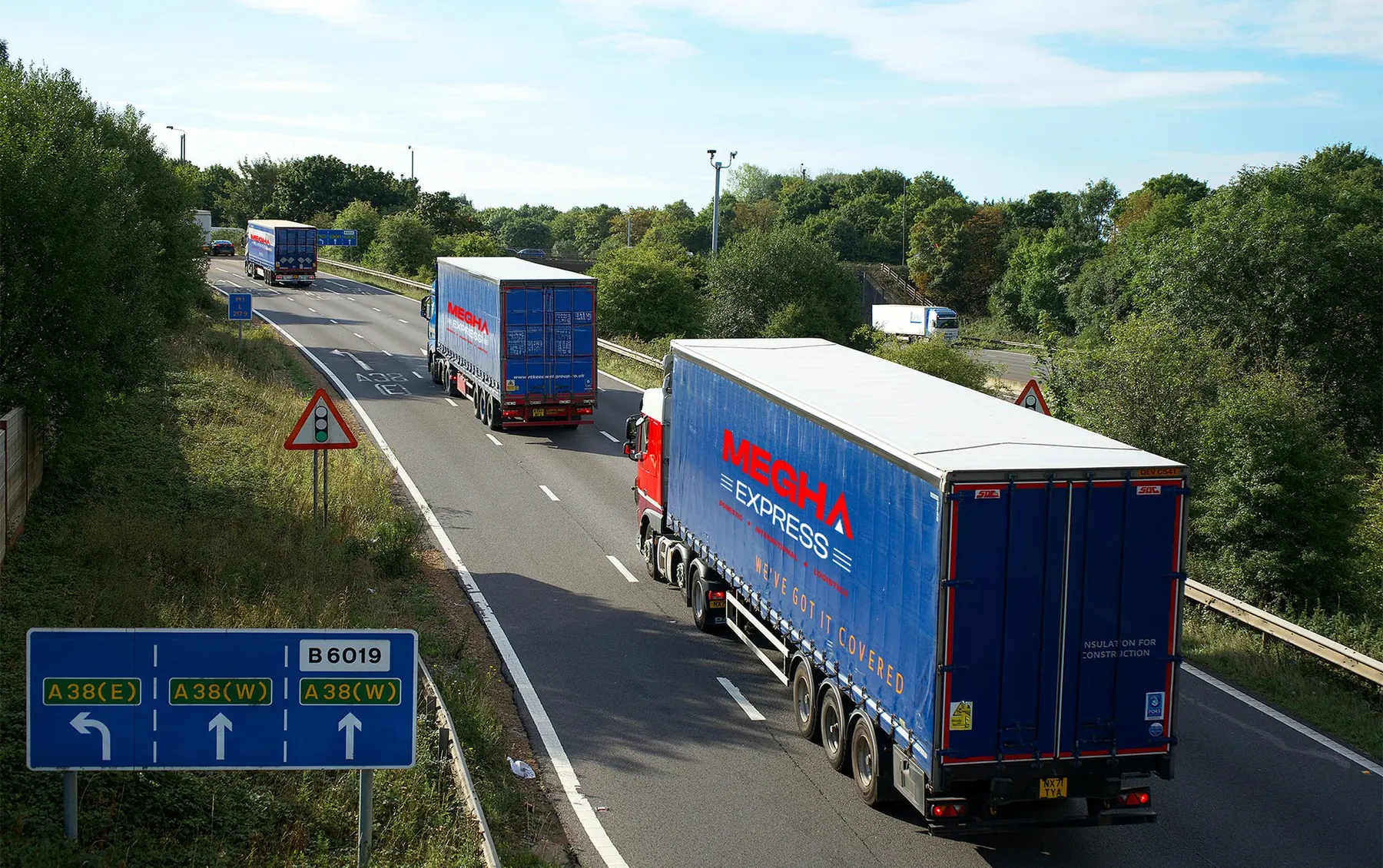 Megha Express branded trucks driving on a highway
